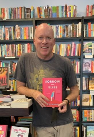 Bookseller Jay holding a copy of Sorrow and Bliss by Meg Mason