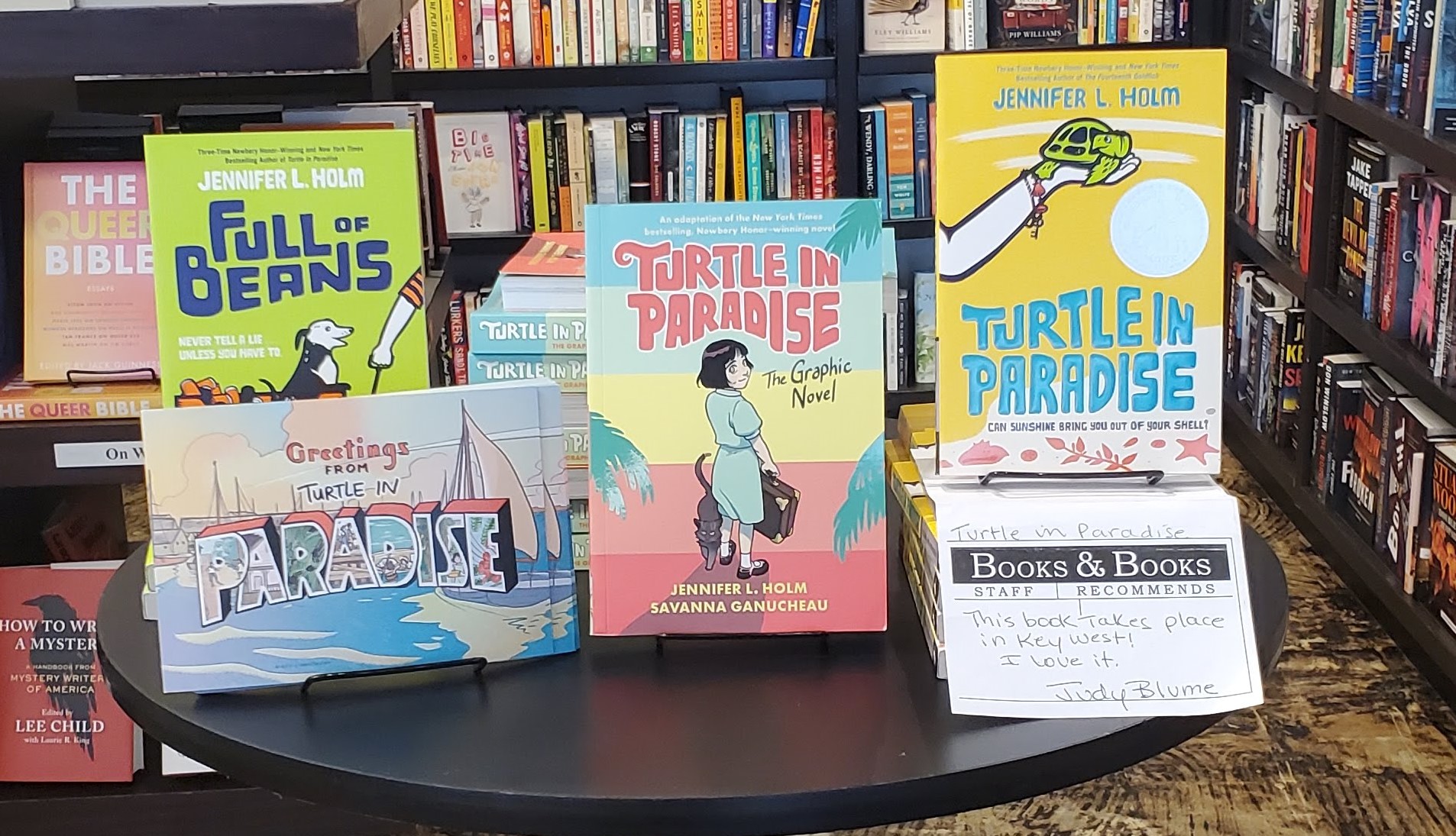 Group of Jennifer Holm's books on a table, including Full of Beans, Turtle in Paradise and Turtle in Paradise: The Graphic Novel