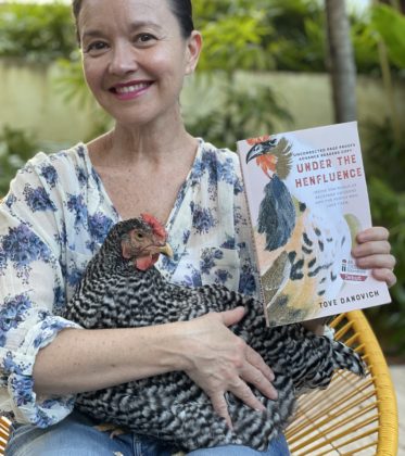 Bookseller Camila with one of her chickens and Under the Henfluence, by Tove Danovich